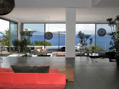a living room with a red couch and large windows at Dililodge in Verghia