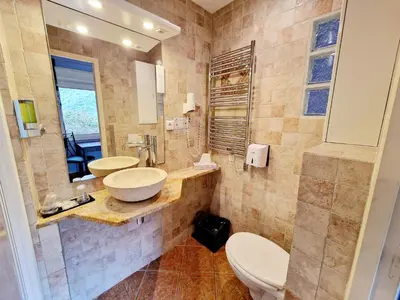 a bathroom with two sinks and a toilet at Hôtel Bella Vista in Porto Ota