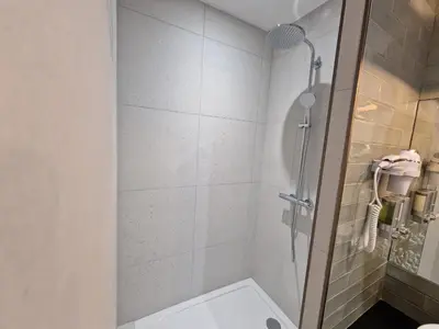 a shower with a glass door in a bathroom at Hôtel Bella Vista in Porto Ota