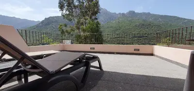 a balcony with a table and a view of mountains at Hôtel Bella Vista in Porto Ota