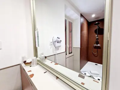 a bathroom with a shower and a mirror at Hôtel Bella Vista in Porto Ota