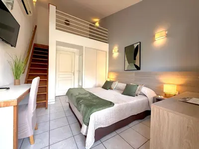 a hotel room with two beds in a room at Hôtel Restaurant L' Empereur in Aléria