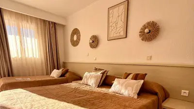 a bedroom with a bed with two green pillows at Hôtel Restaurant L' Empereur in Aléria