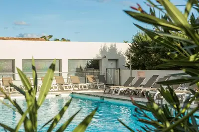a swimming pool with chaise lounges and chairs at Hôtel Spa Restaurant La Madrague in Lucciana