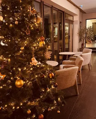 a christmas tree in a room with chairs at Hôtel Spa Restaurant La Madrague in Lucciana