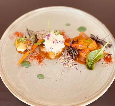 a white plate with food on a table at Hôtel Spa Restaurant La Madrague in Lucciana