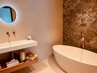 a bathroom with a white tub and a sink at Hôtel Spa Restaurant La Madrague in Lucciana