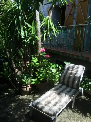 a bench sitting in a yard next to some plants at GITE , Maison de vacances avec extérieur et terrasse fleurie meublé tourisme 3 étoiles in Poggio-di-Tallano