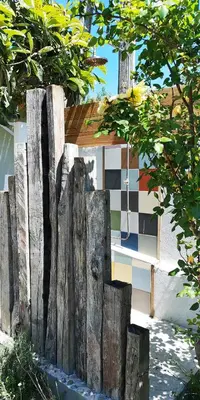 a wooden fence in front of a building at Les jardins de Porto Pollo in Porto Pollo
