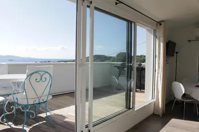 a room with a balcony with sliding glass doors at Les jardins de Porto Pollo in Porto Pollo