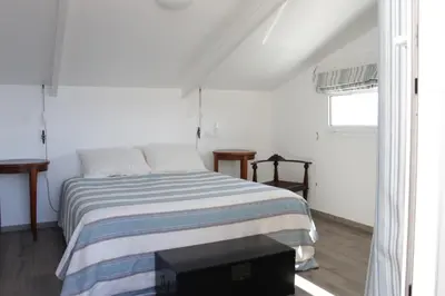 a white bedroom with a bed and a window at Les jardins de Porto Pollo in Porto Pollo