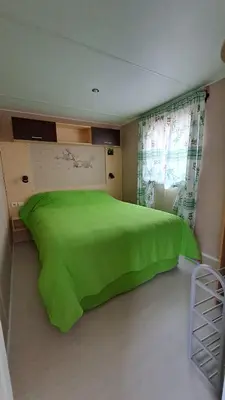 a bedroom with a green bed and a window at Muntagn' home in Corte