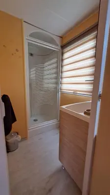a bathroom with a tub and a shower with a window at Muntagn' home in Corte