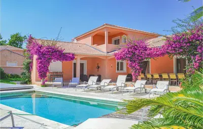 a house with a swimming pool and purple flowers at Cozy Home In Moriani Plage With Wifi in Moriani Plage