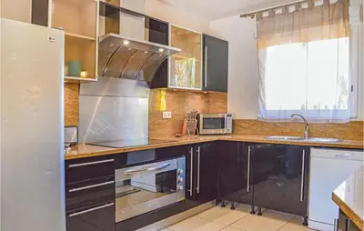 a kitchen with black cabinets and a stainless steel appliances at Cozy Home In Moriani Plage With Wifi in Moriani Plage