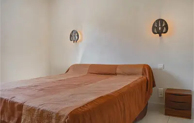 a bedroom with a bed and two lights on the wall at Cozy Home In Moriani Plage With Wifi in Moriani Plage