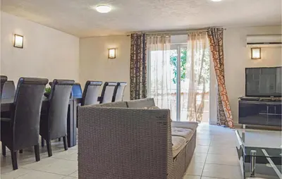 a living room with a couch and a table and a television at Cozy Home In Moriani Plage With Wifi in Moriani Plage