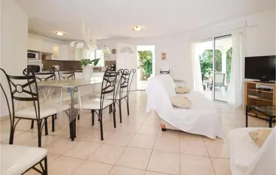 a dining room and living room with a table and chairs at 3 Bedroom Nice Home In Moriani Plage in Moriani Plage