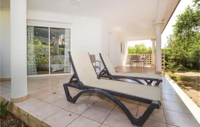 a bench sitting on the porch of a house at 3 Bedroom Nice Home In Moriani Plage in Moriani Plage