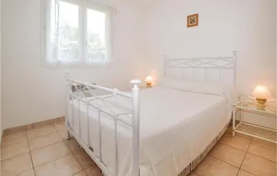 a white bedroom with a white bed and a window at 3 Bedroom Nice Home In Moriani Plage in Moriani Plage