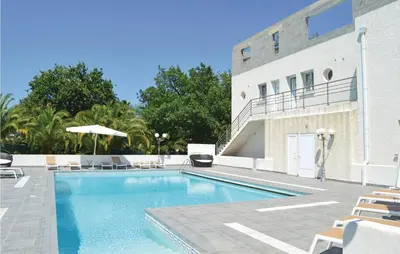 a swimming pool in front of a building at Nice Apartment In Moriani Plage in Moriani Plage