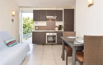 a kitchen with a table and a dining room at Nice Apartment In Moriani Plage in Moriani Plage