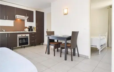a kitchen and dining room with a table and chairs at Nice Apartment In Moriani Plage in Moriani Plage