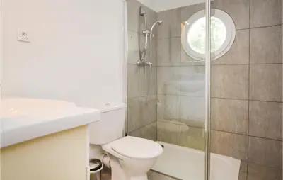 a bathroom with a toilet and a glass shower at Nice Apartment In Moriani Plage in Moriani Plage