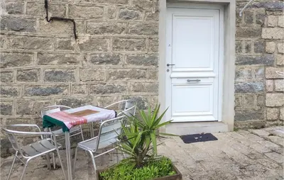 a table and chairs in front of a white door at Nice Apartment In Sollacaro With Wifi in Sollacaro