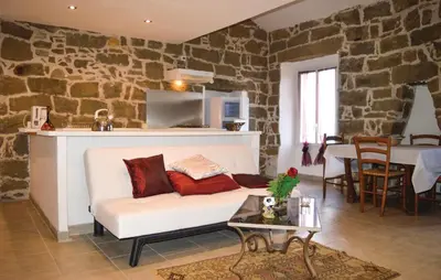 a living room with a white couch and a stone wall at Nice Apartment In Sollacaro With Wifi in Sollacaro