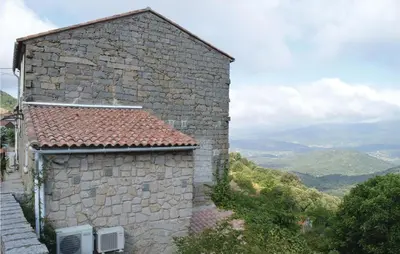 a stone building with a view of the mountains at Nice Apartment In Sollacaro With Wifi in Sollacaro