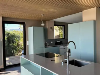 a patio with a table and chairs and a view of the water at Villa Libecciu in Sainte-Lucie de Porto-Vecchio