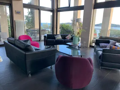 a living room with couches and chairs and a table at Villa Libecciu in Sainte-Lucie de Porto-Vecchio