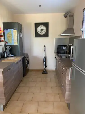 a kitchen with a clock on the wall and a counter at Appartement I Cardellini in Sari Solenzara