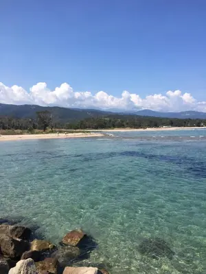 a view of a beach with blue water and rocks at Appartement I Cardellini in Sari Solenzara