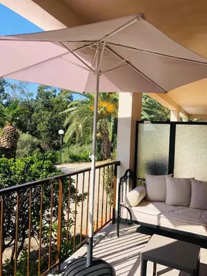 a patio with an umbrella on a deck at Appartement I Cardellini in Sari Solenzara