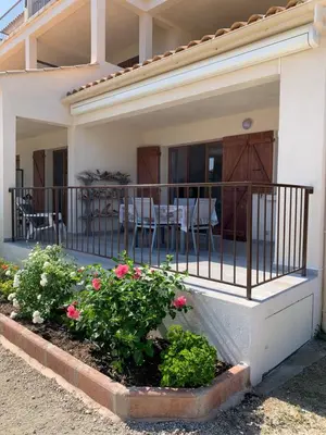 a house with a balcony with pink flowers at Appartement I Cardellini in Sari Solenzara