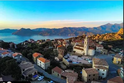 an aerial view of a town with a lake and mountains at A Stalla in Piana