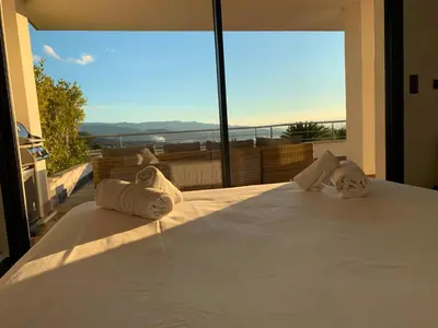 a bedroom with a bed with towels on it at Résidence Les Jardins du Fort in Porticcio