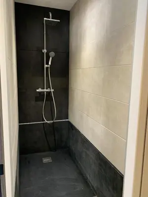 a bathroom with a shower with a shower head at Résidence Les Jardins du Fort in Porticcio