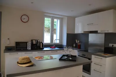 a kitchen with a counter with a clock on the wall at maison corse en balagne in Cateri