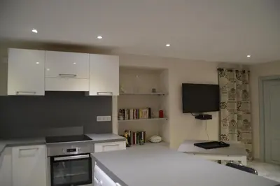 a kitchen with white cabinets and a stove top oven at maison corse en balagne in Cateri