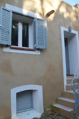 a building with a door and a window and stairs at maison corse en balagne in Cateri