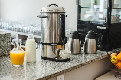 a blender on a counter with a glass of orange juice at B&B A Chjusellina in Corte