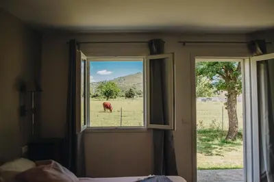 a room with a window with a cow in a field at B&B A Chjusellina in Corte