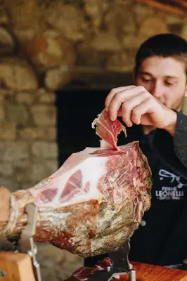 a man is holding a piece of meat at B&B A Chjusellina in Corte