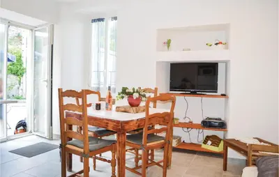 a dining room with a table and chairs and a tv at Beautiful Apartment In Sollacaro in Sollacaro