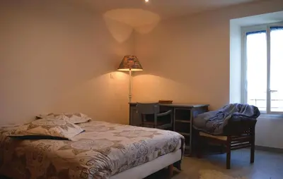 a bedroom with a bed and a desk and a lamp at Beautiful Apartment In Sollacaro in Sollacaro