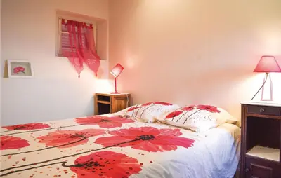 a bedroom with a bed with red flowers on it at Beautiful Apartment In Sollacaro in Sollacaro