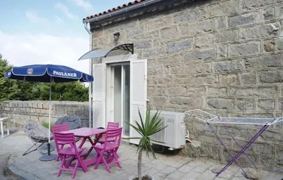 a patio with a table and chairs and an umbrella at Beautiful Apartment In Sollacaro in Sollacaro